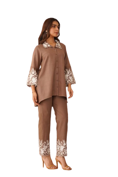 Woman wearing brown embroidered tunic and pants set with floral details.